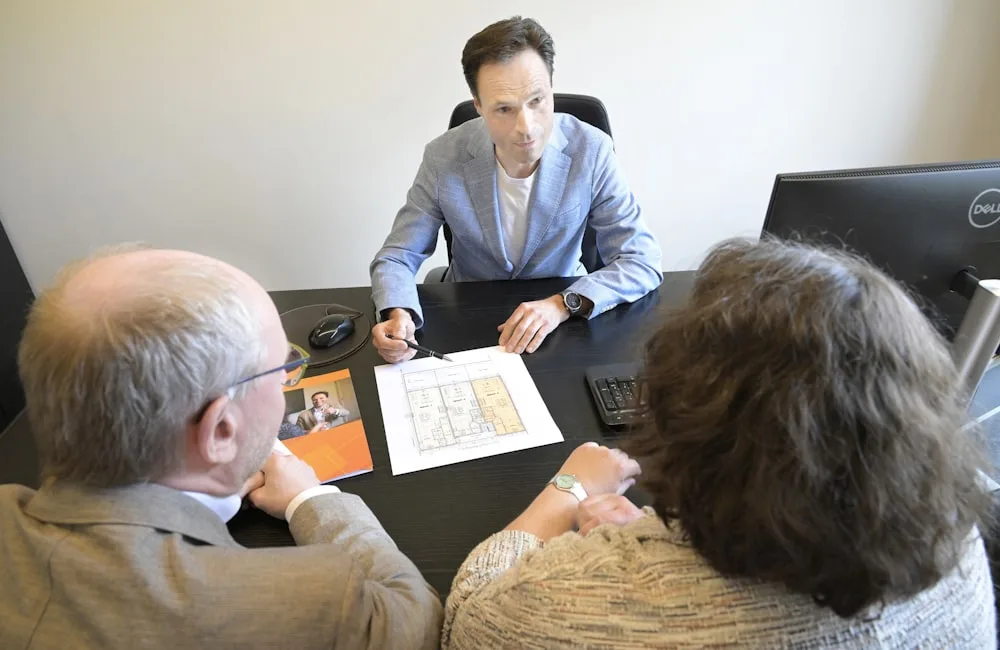 Arquitecta de Raíz reunida con clientes revisando los planos de su proyecto